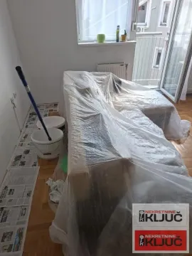 Dnevna soba sa nameštajem prekrivenim najlonom tokom renoviranja. - image 5