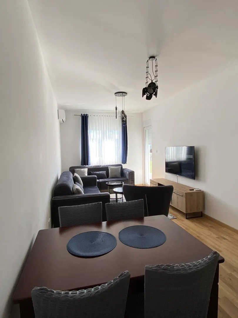 Bright living room featuring a dining table and sofa seating.