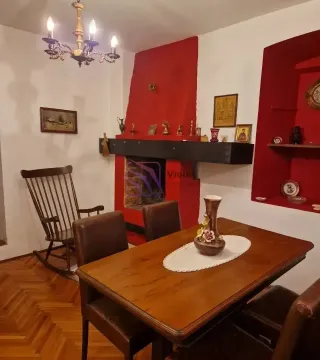 Dnevni boravak sa trpezarijskim stolom, kaminom i drvenim namještajem. - image 10