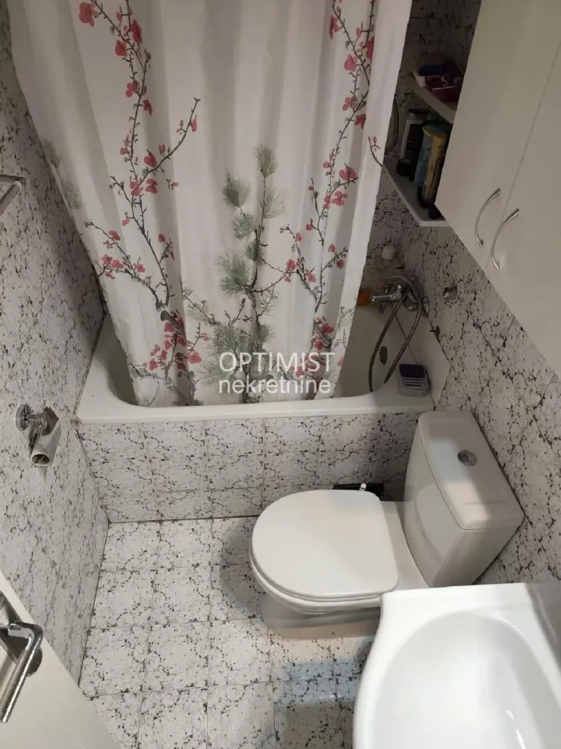 Manje kupatilo sa kadom, wc šoljom i umivaonikom.