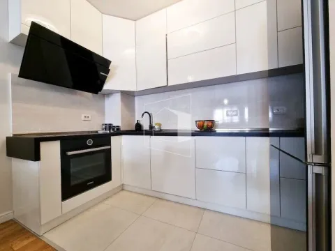 Moderna bijela kuhinja sa ugradnim elementima i crnim radnim površinama. - image 7