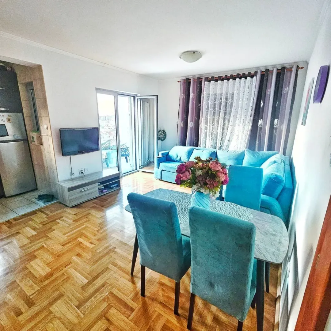 Living room with a sofa set, dining table, and access to the terrace.