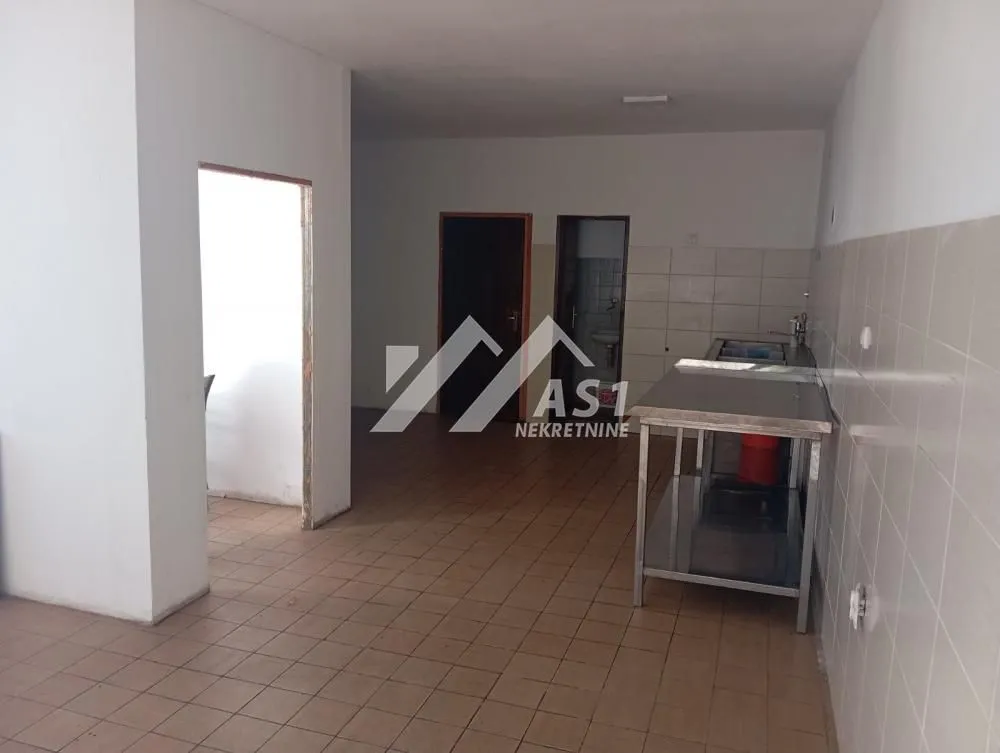 Empty kitchen with tiled floor and work units.