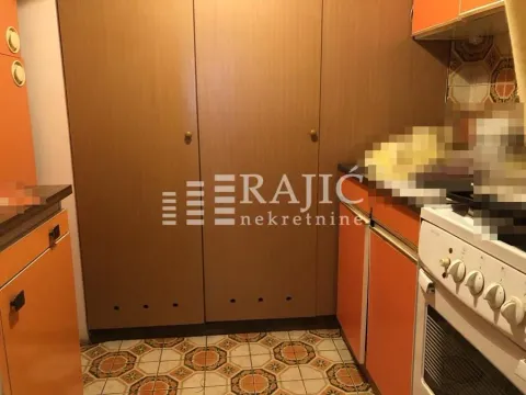 Older kitchen with wooden cabinets and a stove. - image 15