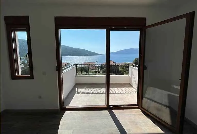 Prazna prostorija sa izlazom na terasu i pogledom na more.