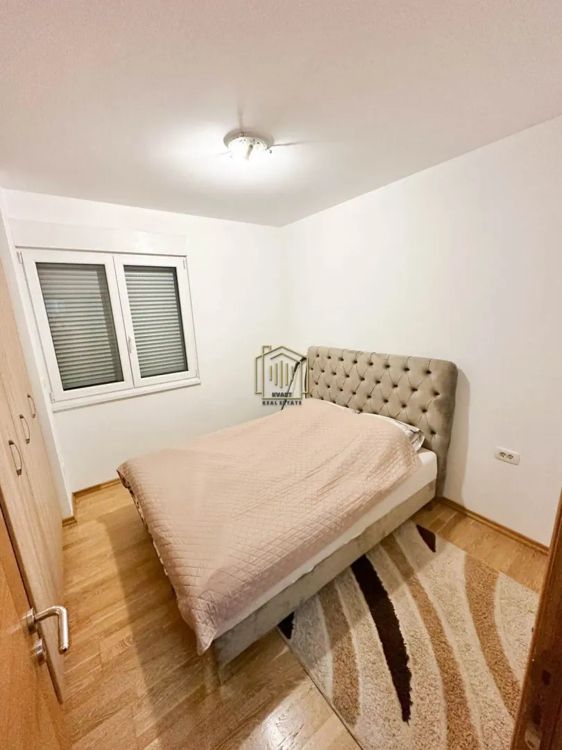 Furnished bedroom with a double bed, wardrobe, and a window.