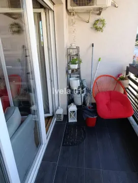 Manji namešteni balkon sa staklenim kliznim vratima i crvenom foteljom. - image 17