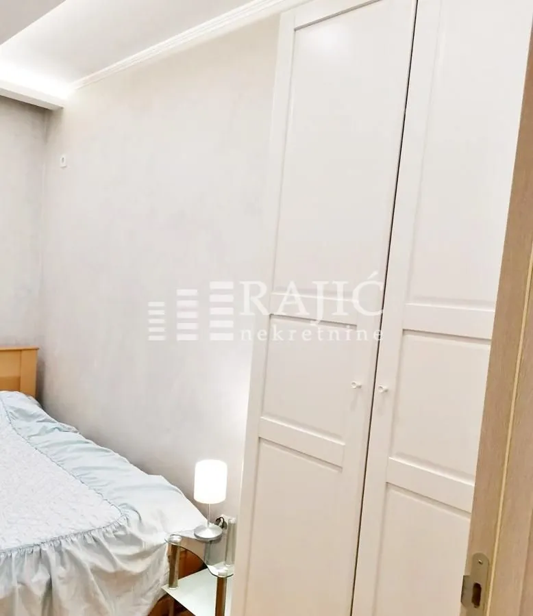 Bedroom with a bed and a white wardrobe.