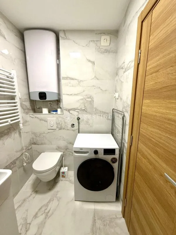 Modern bathroom with a washing machine and built-in sanitary fixtures.