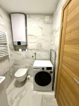 Modern bathroom with a washing machine and built-in sanitary fixtures. - image 11