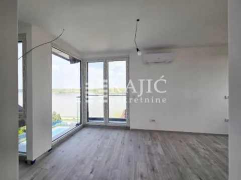 Empty room with wooden flooring, air conditioning, and large windows. - image 6
