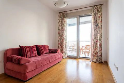 Svijetla dnevna soba sa crvenom sofom i izlazom na balkon. - image 19
