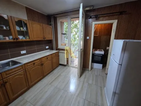 Kitchen with wooden cabinetry, refrigerator, and access to the terrace. - image 3