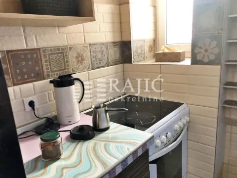 Small kitchen with a stove and decorative tiles. - image 11