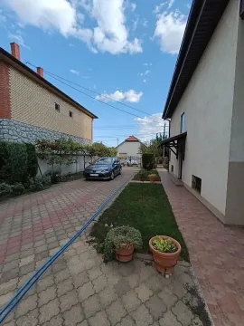 Dvorište sa popločanim stazama i parkiranim automobilom pored kuće. - image 10