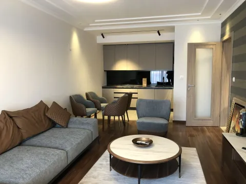 Bright living room with a kitchen in the background. - image 9