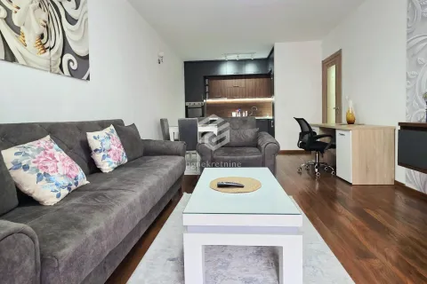 Living room with sofa, coffee table, and a view of the kitchen in the background. - image 16
