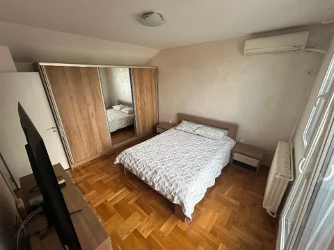 Nameštena spavaća soba sa bračnim krevetom, velikim garderoberom i televizorom. - image 14