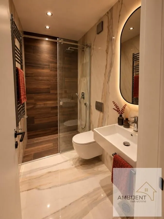 Moderno kupatilo sa tuš kabinom, umivaonikom i ugradnom wc šoljom.