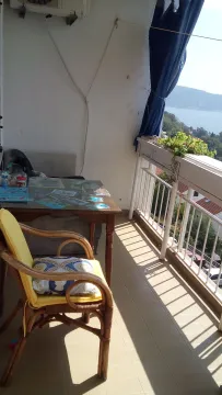 Namještena terasa sa stolom, stolicom i pogledom na more. - image 3