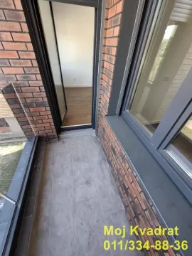 Manji balkon sa sivim pločicama i pogledom ka unutrašnjosti stana. - image 10
