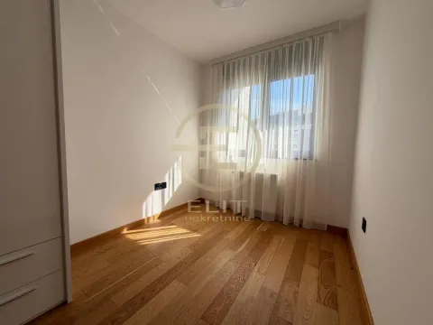 Prazna soba sa drvenim podom i prozorom prekrivenim zavesama. - image 17
