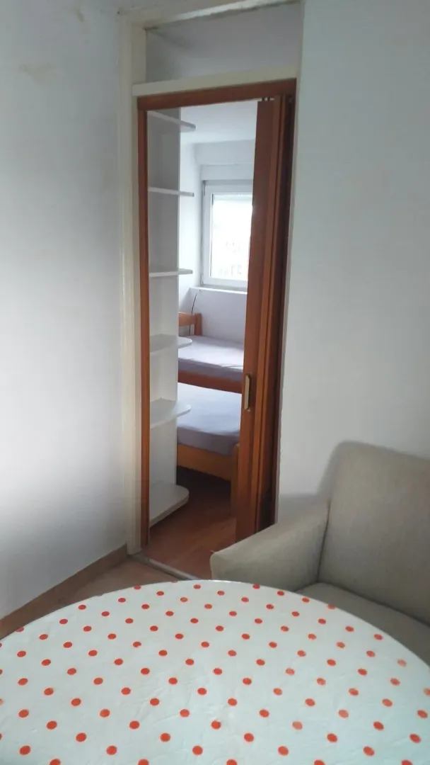 View through a doorway towards a bedroom with a bunk bed.