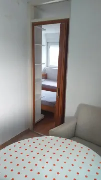 View through a doorway towards a bedroom with a bunk bed. - image 6