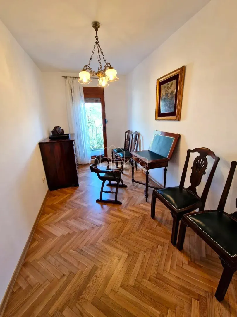 Living room with wooden furniture, parquet flooring, and access to the terrace.