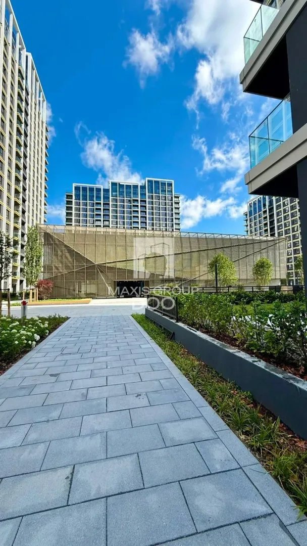 A paved pathway overlooking modern residential buildings and a landscaped courtyard.
