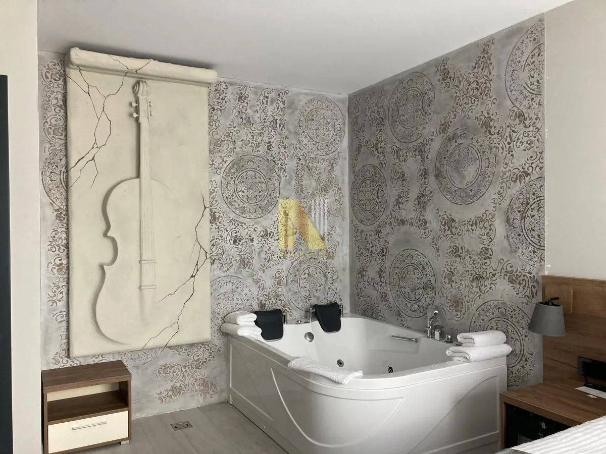 Modern bathroom with a whirlpool tub and a decorative wall featuring a violin motif.