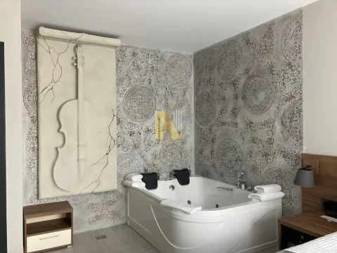 Modern bathroom with a whirlpool tub and a decorative wall featuring a violin motif. - image 3