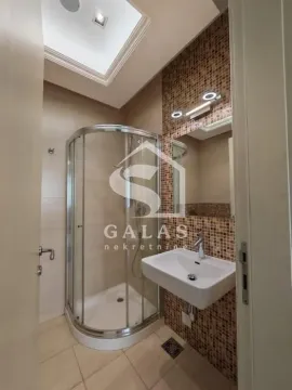 Bathroom equipped with a shower cabin, washbasin, and lighted mirror. - image 11
