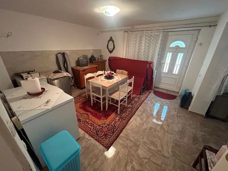 Living room with a dining table and a door leading outside.