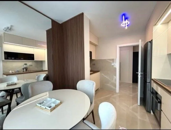 Moderna kuhinja sa trpezarijom i ugradnim elementima.