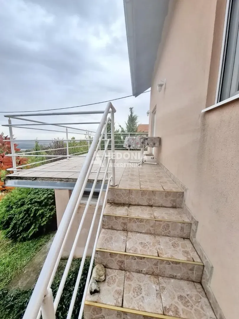 Spoljne stepenice koje vode do terase sa ogradom.