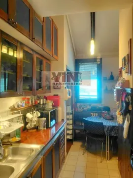 Kitchen with wooden cabinetry and a dining table. - image 10