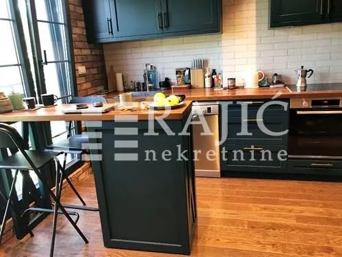 Modern kitchen with dark cabinetry and a dining table.
