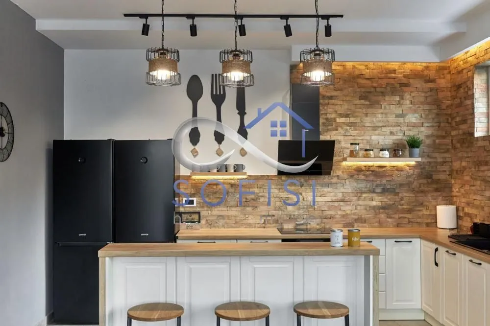 Modern kitchen with a breakfast bar, cabinetry, and built-in appliances.