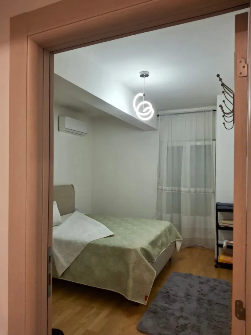 View from the hallway into a furnished bedroom with a double bed.