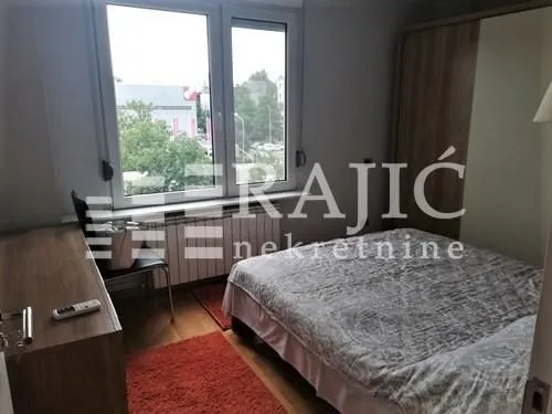 Furnished bedroom with a double bed, wardrobe, and a desk.