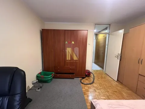 Spavaća soba sa velikim drvenim ormarima i krevetom. - image 6