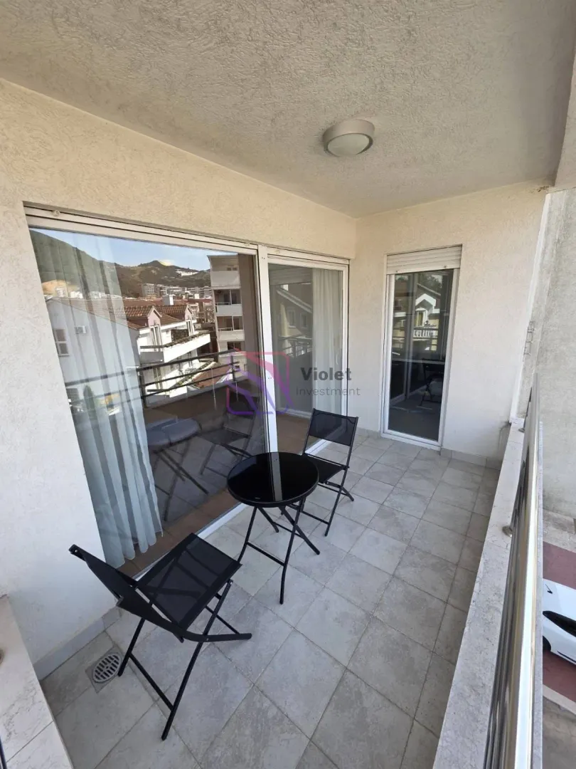 Covered balcony with patio furniture and a view of the surroundings.