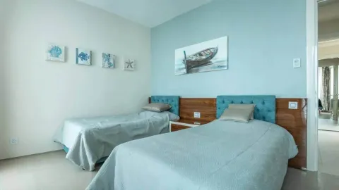Spavaća soba sa dva odvojena kreveta i plavim detaljnim zidom. - image 6