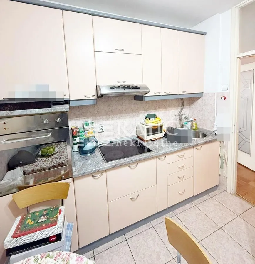 Smaller kitchen with light cabinets and built-in appliances.