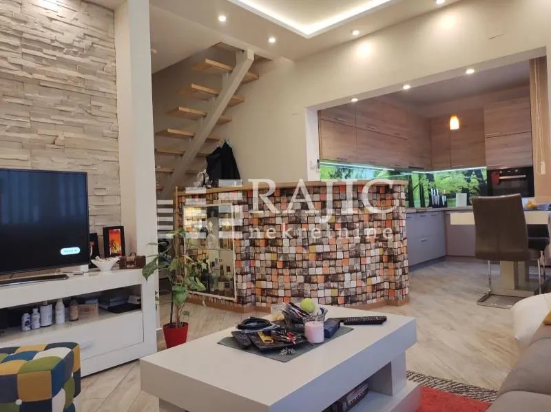 Spacious living room with a view of the kitchen and staircase.
