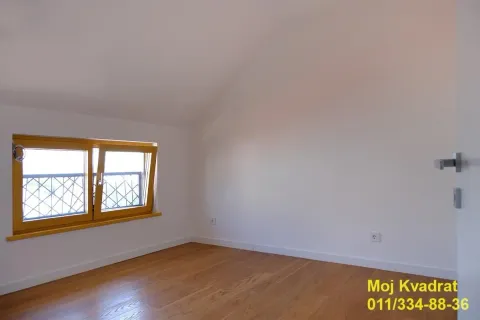 Prazna soba sa kosim plafonom i drvenim podom. - image 9