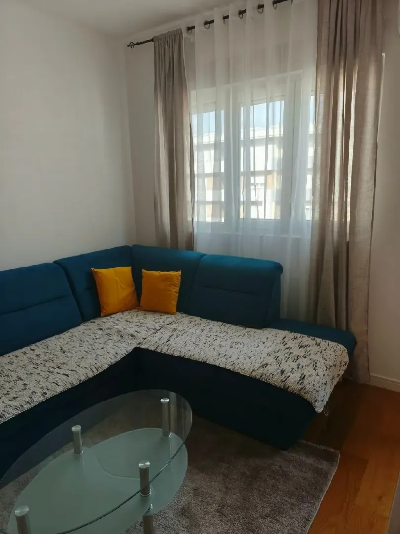 Living room with a sectional sofa, coffee table, and window.