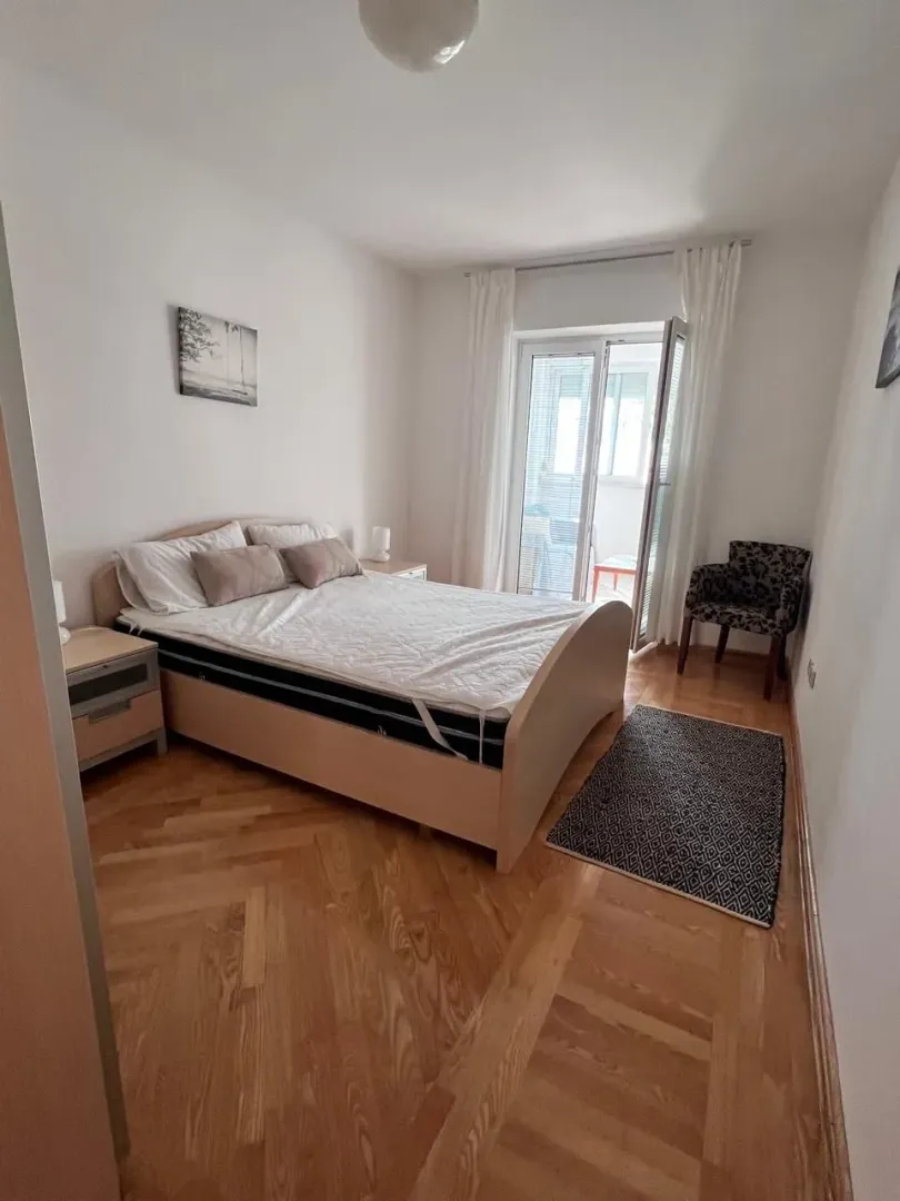 Svijetla spavaća soba sa izlazom na balkon.