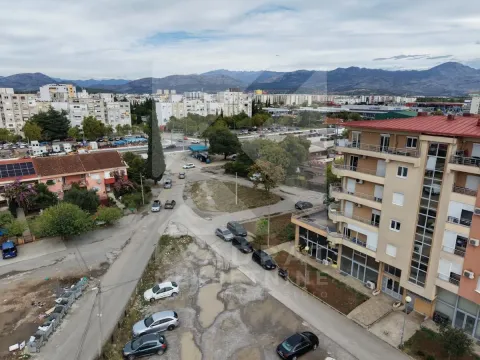 View from the apartment overlooking city streets, surrounding buildings, and mountains in the background. - image 7